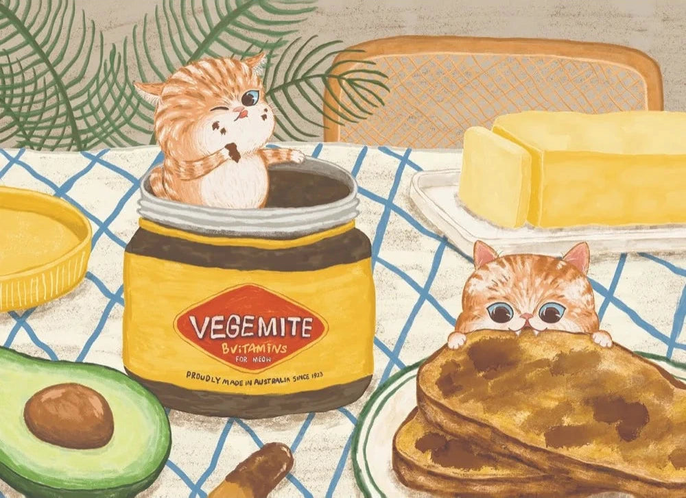Illustration of cats with Vegemite jar, avocado, and toast on a table.